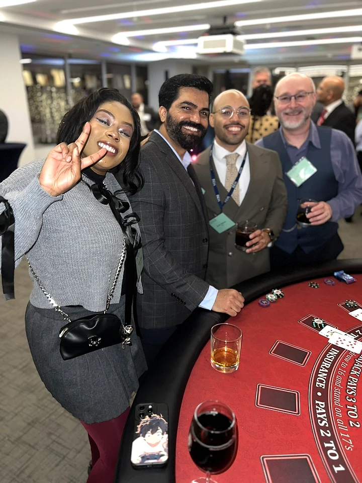 Company-event guests gathered around a casino gaming table.