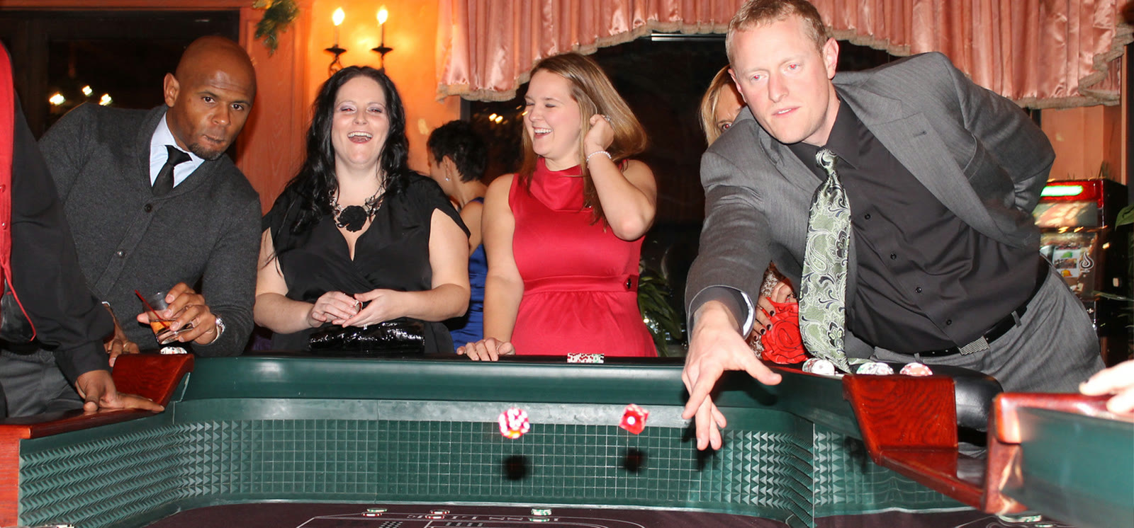 Guests gather around a dealer-led casino table at an event.